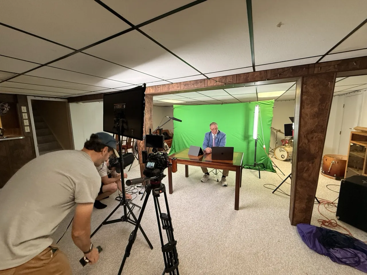 Al on camera, lining up Ken as the newscast anchor at a desk in front of a green screen