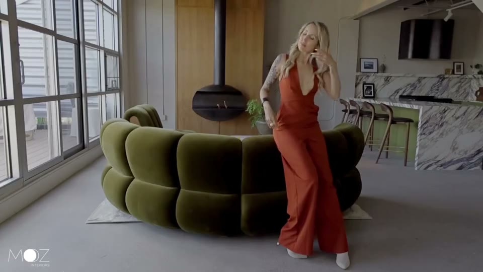 Lyz beside the couch in a MOZ-designed interior